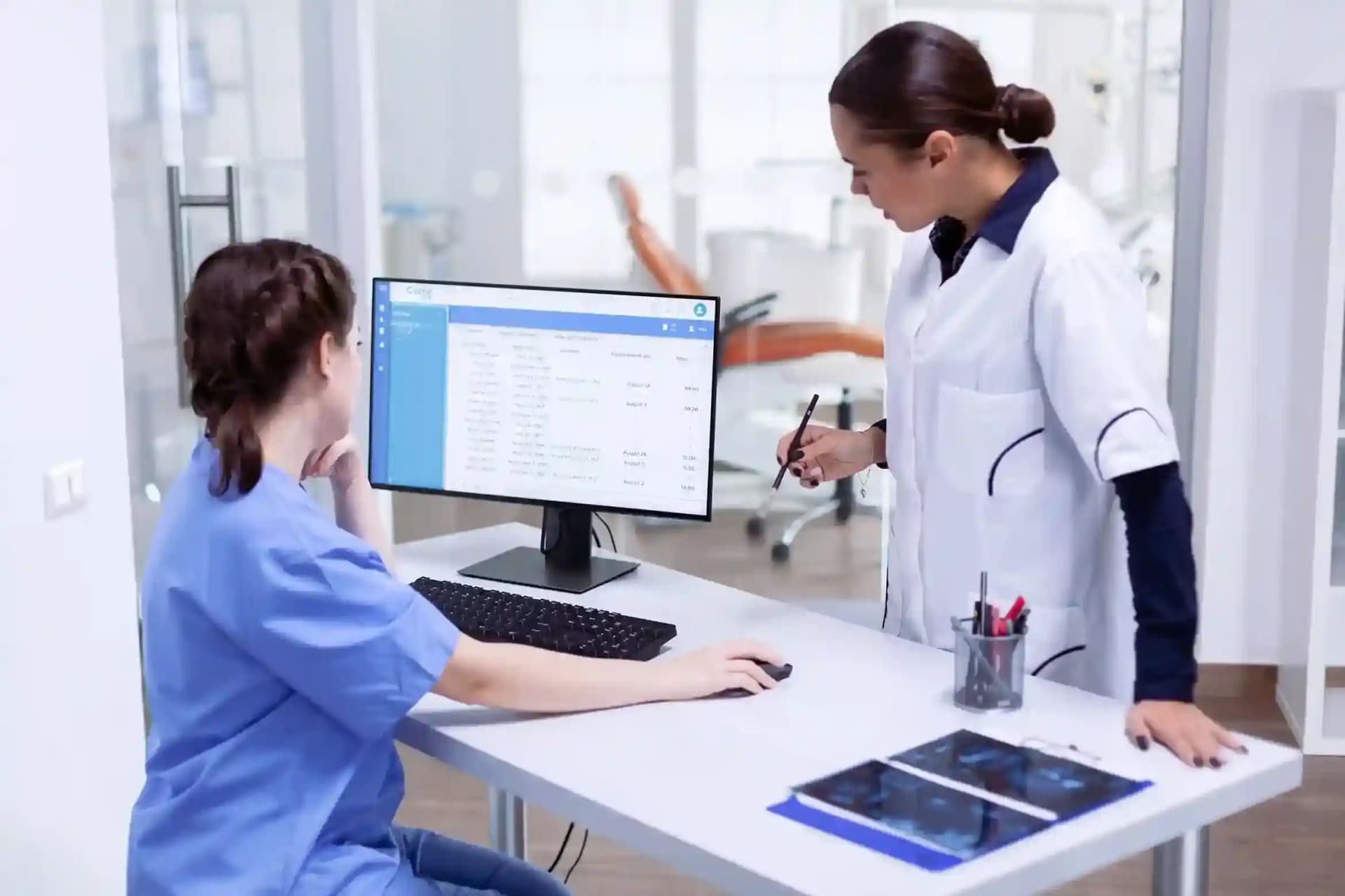 Medical professionals using computer systems in a clinic setting, illustrating specialized software solutions for healthcare-industries.